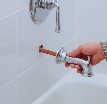 Plumber installing water faucet in the with bathroom