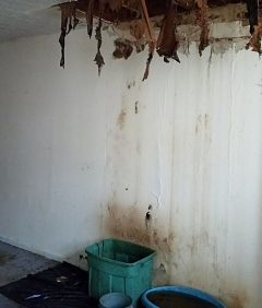 Water damage from roof leak in a house with ceiling falling in